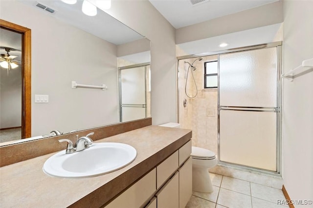 bathroom featuring tile patterned floors, a shower with door, vanity, and toilet