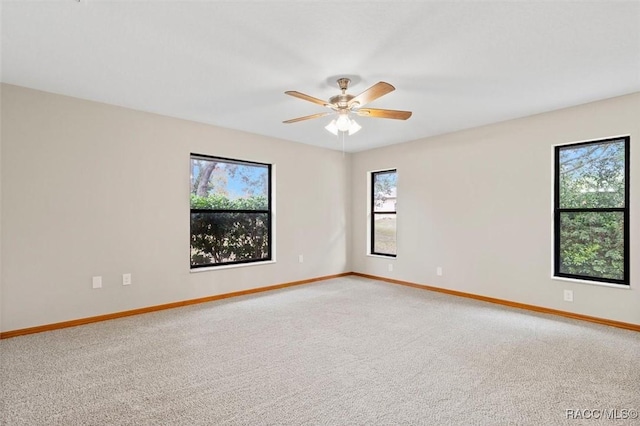 carpeted empty room featuring a wealth of natural light and ceiling fan