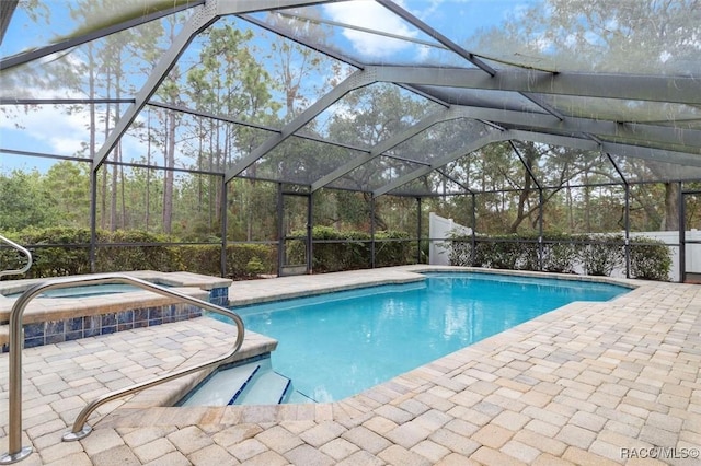 view of pool with a lanai, a patio area, and an in ground hot tub