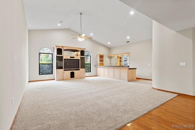 unfurnished living room featuring ceiling fan, light hardwood / wood-style floors, and high vaulted ceiling