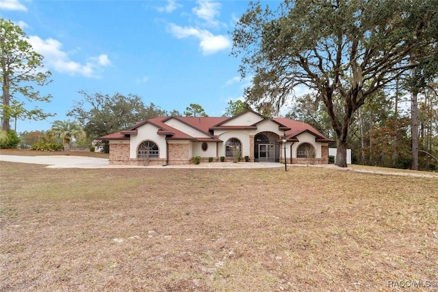 mediterranean / spanish-style home with a front lawn