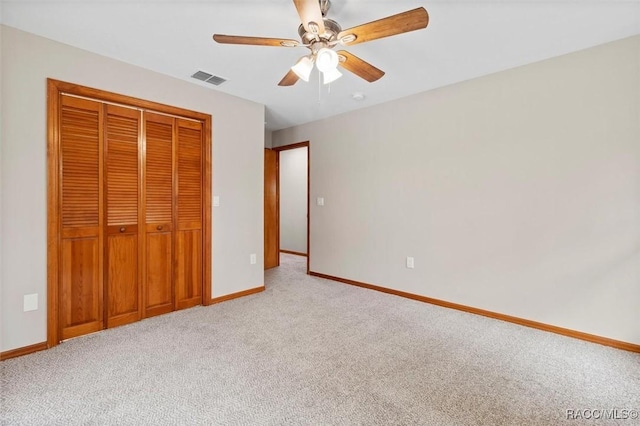 unfurnished bedroom featuring ceiling fan, light colored carpet, and a closet