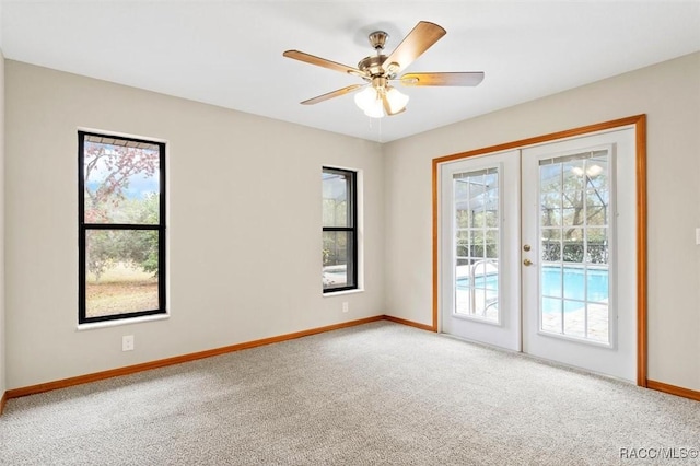 carpeted empty room with ceiling fan and french doors