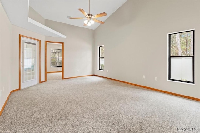 empty room featuring high vaulted ceiling, ceiling fan, carpet floors, and a wealth of natural light