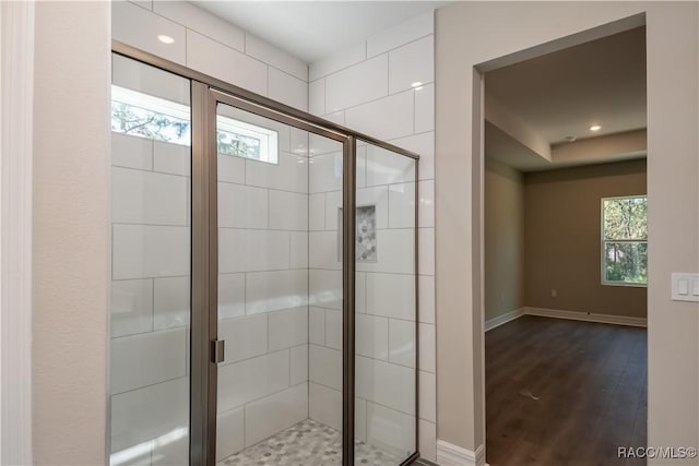 bathroom featuring wood-type flooring and a shower with door