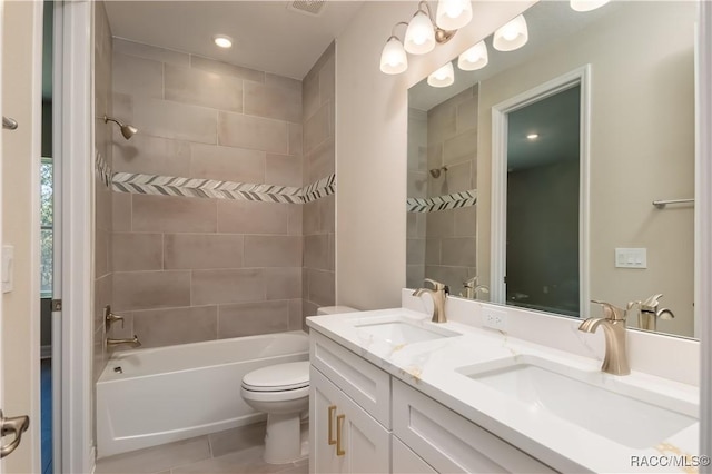 full bathroom with tile patterned floors, tiled shower / bath combo, toilet, and vanity