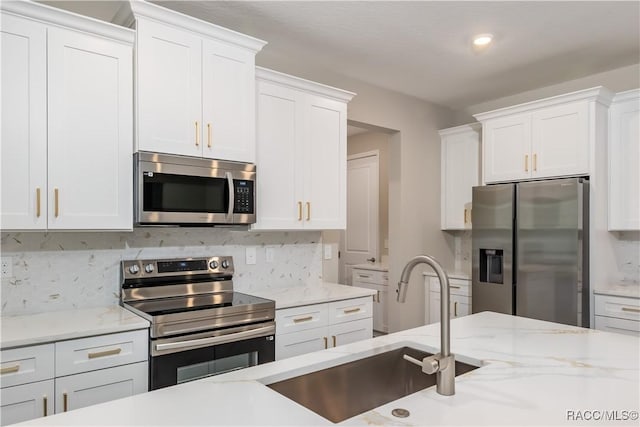 kitchen with stainless steel appliances, white cabinetry, and sink