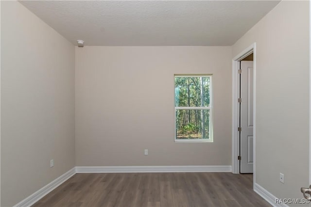 spare room with a textured ceiling and hardwood / wood-style flooring