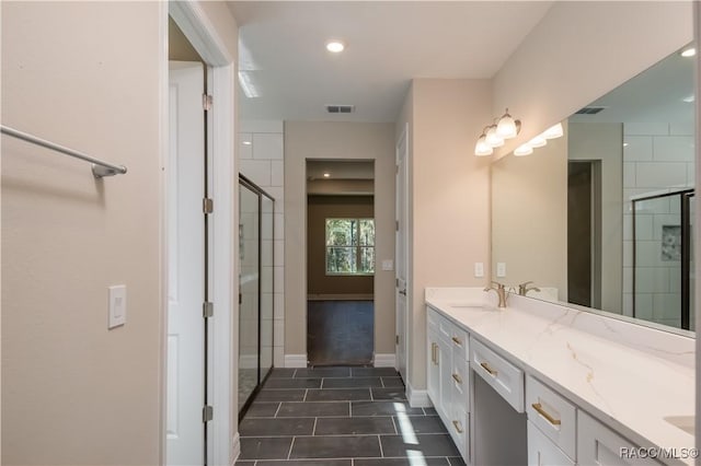 bathroom with tile patterned floors, vanity, and an enclosed shower