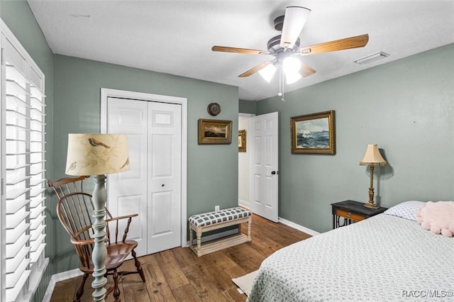 bedroom featuring ceiling fan, a closet, and dark wood-type flooring