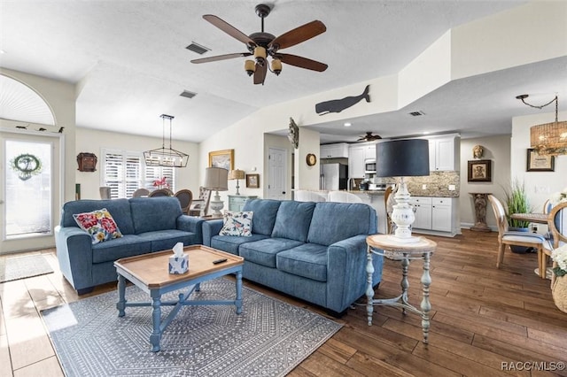 living room featuring lofted ceiling, dark hardwood / wood-style floors, and an inviting chandelier