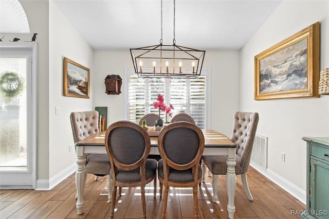 dining room featuring hardwood / wood-style floors, a notable chandelier, and a wealth of natural light