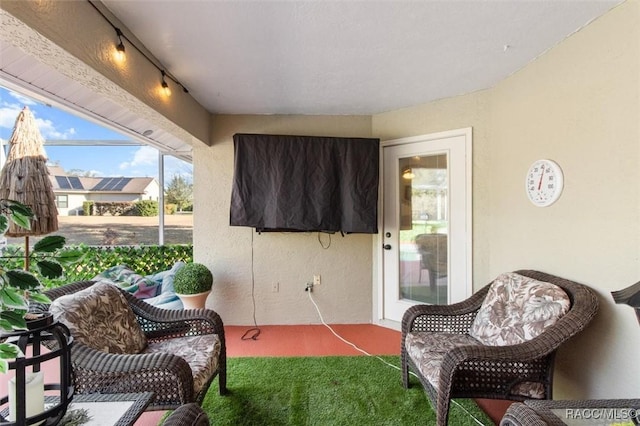 sunroom / solarium featuring track lighting