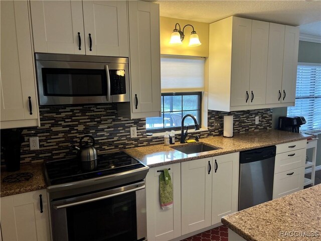 3809 N Seminole Pt, Crystal River, FL 34428 - kitchen featuring appliances with stainless steel finishes, a sink, backsplash, and white cabinetry