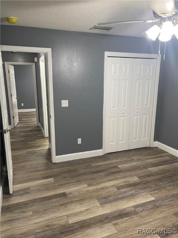 interior space with ceiling fan, dark hardwood / wood-style flooring, and a closet