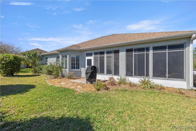 2083 NW 57th Ct, Ocala, FL 34482 - rear view of house featuring a sunroom, stucco siding, and a yard