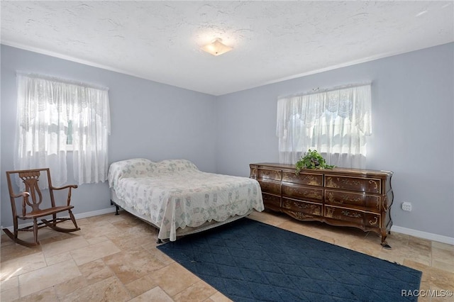 bedroom featuring baseboards and a textured ceiling