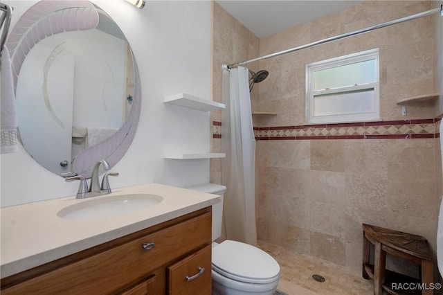 bathroom with toilet, tiled shower, and vanity