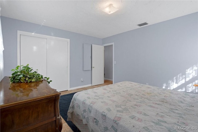 bedroom with a closet, visible vents, and baseboards