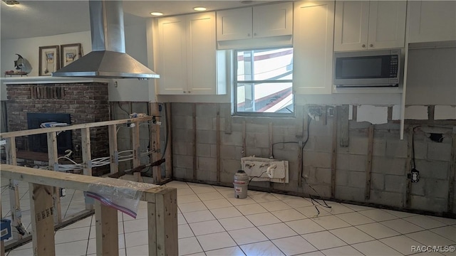 kitchen with white cabinets, stainless steel microwave, and extractor fan