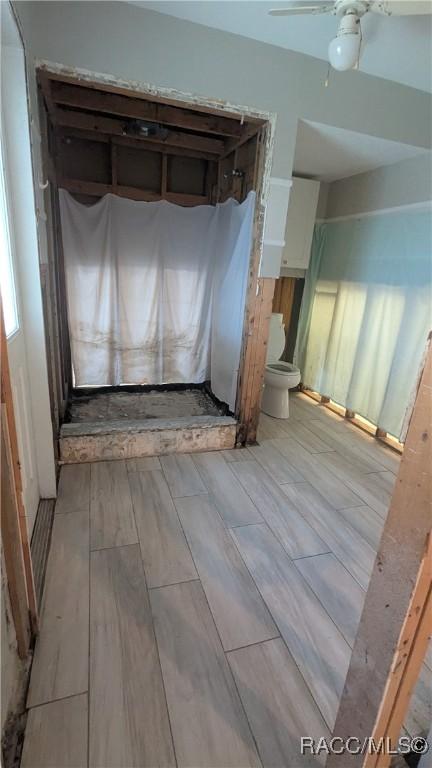 interior space featuring a ceiling fan and wood finish floors