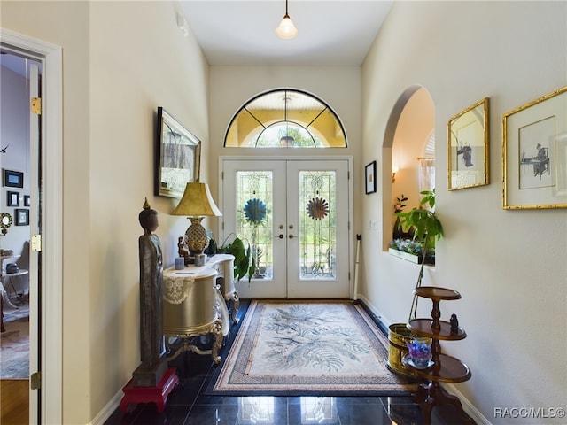 foyer featuring french doors and dark tile patterned floors