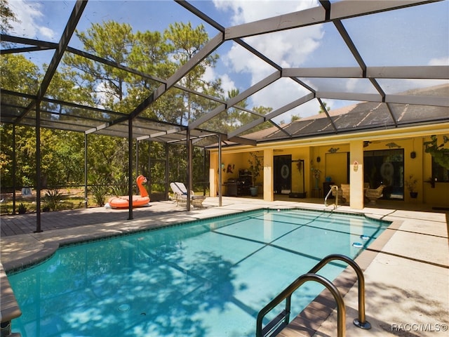 view of swimming pool featuring ceiling fan, a patio, and glass enclosure