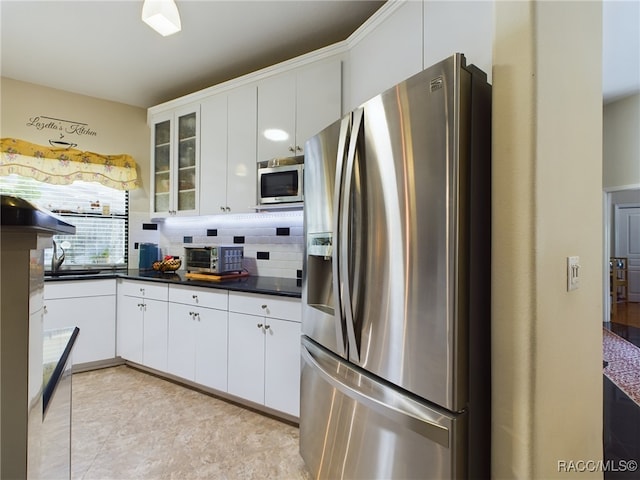 kitchen featuring appliances with stainless steel finishes, tasteful backsplash, and white cabinetry