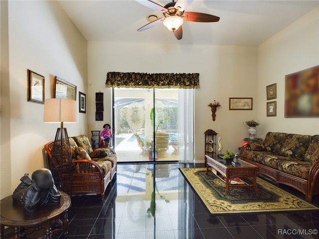 living room featuring ceiling fan and dark tile patterned floors