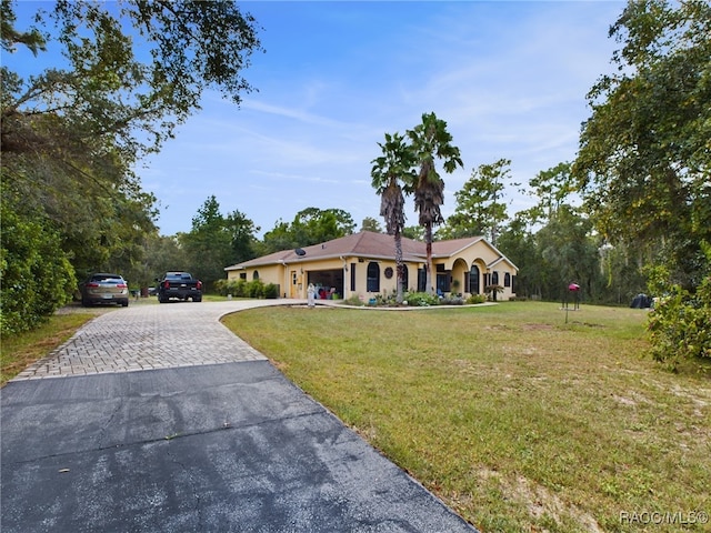 view of front of house with a garage and a front lawn