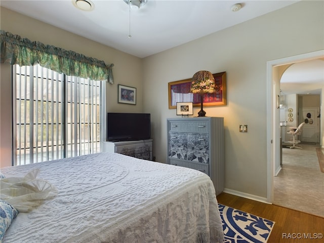 bedroom with hardwood / wood-style flooring, ceiling fan, and access to exterior