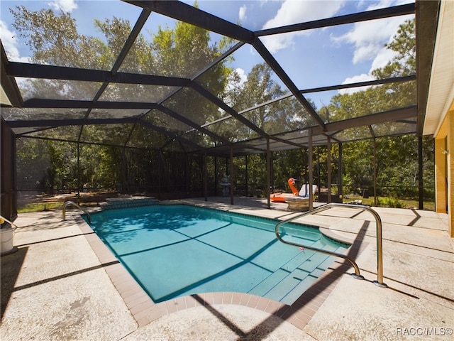 view of swimming pool with glass enclosure and a patio