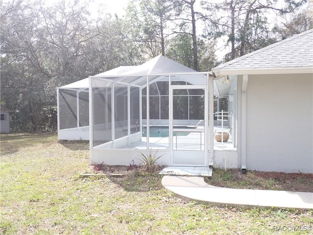 view of yard featuring an outdoor pool and glass enclosure