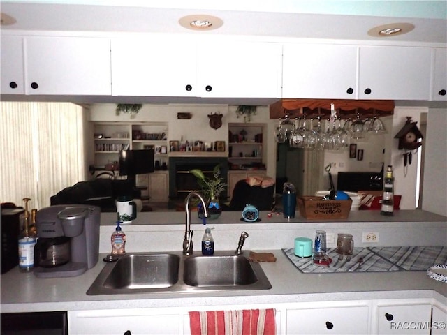 kitchen featuring white cabinets, light countertops, and a sink