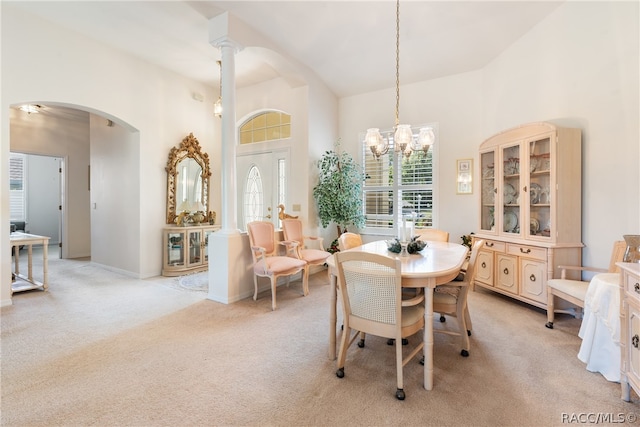 dining area with light colored carpet, vaulted ceiling, and a notable chandelier