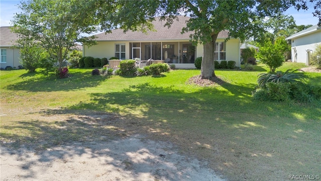 rear view of house featuring a yard and a sunroom