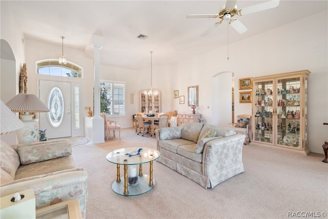 carpeted living room featuring ceiling fan with notable chandelier