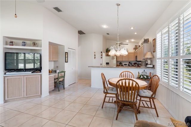 dining space with light tile patterned floors, an inviting chandelier, and a wealth of natural light