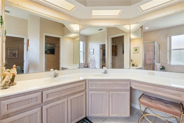 bathroom featuring tile patterned floors, a skylight, a shower with door, and vanity