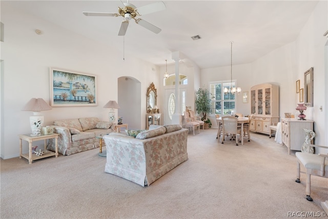 carpeted living room featuring ceiling fan with notable chandelier