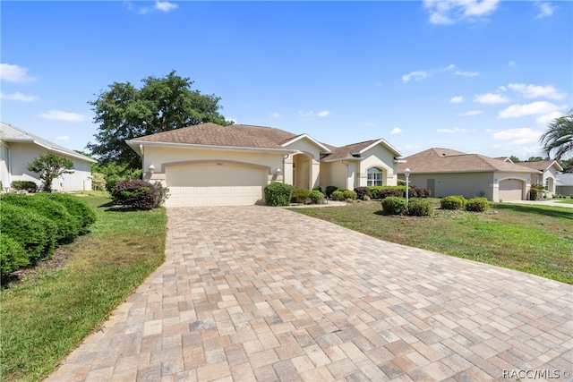 single story home with a garage and a front lawn