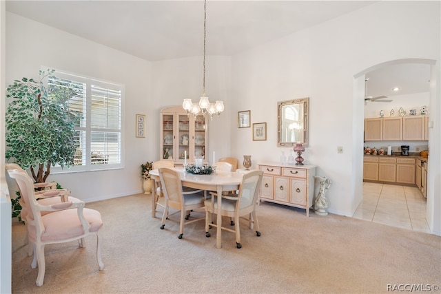 carpeted dining area featuring ceiling fan with notable chandelier