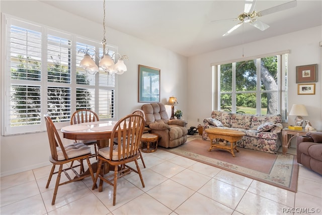 tiled dining room featuring ceiling fan with notable chandelier and a wealth of natural light