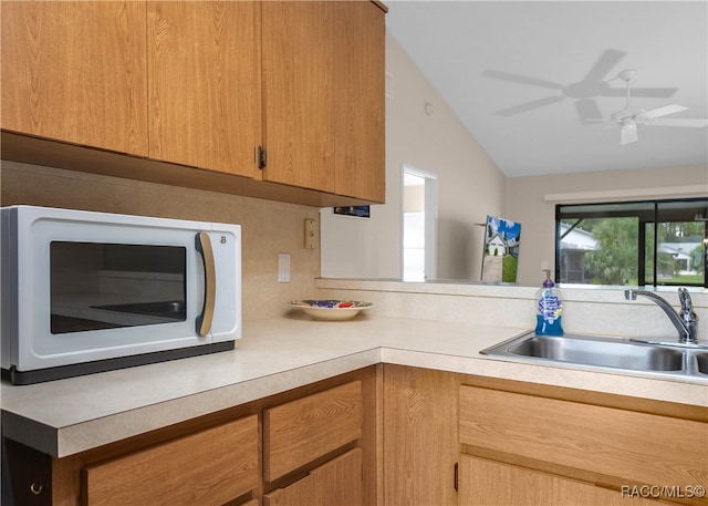 kitchen with backsplash, ceiling fan, sink, and vaulted ceiling