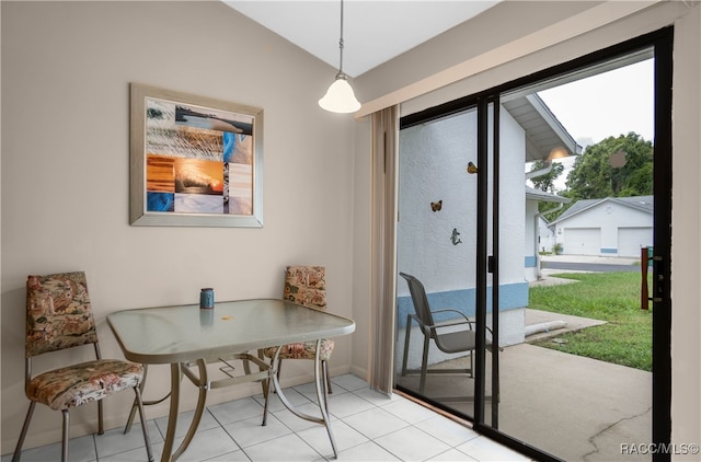 tiled dining space featuring vaulted ceiling