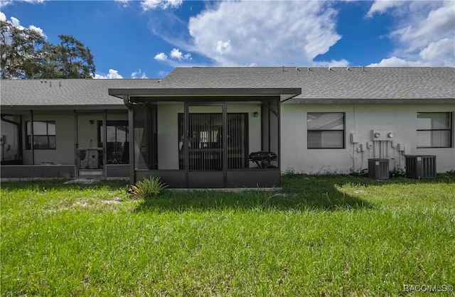 rear view of property with a yard, central AC, and a sunroom