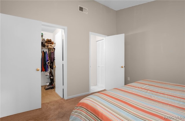 carpeted bedroom featuring a spacious closet and a closet