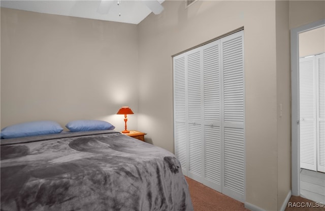 carpeted bedroom with ceiling fan and a closet