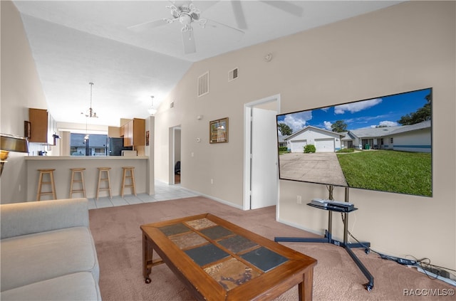 living room featuring light carpet, high vaulted ceiling, and ceiling fan with notable chandelier