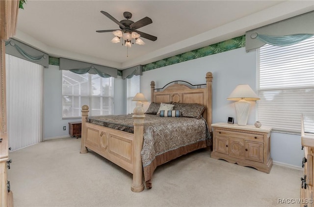 bedroom featuring light carpet, baseboards, and ceiling fan